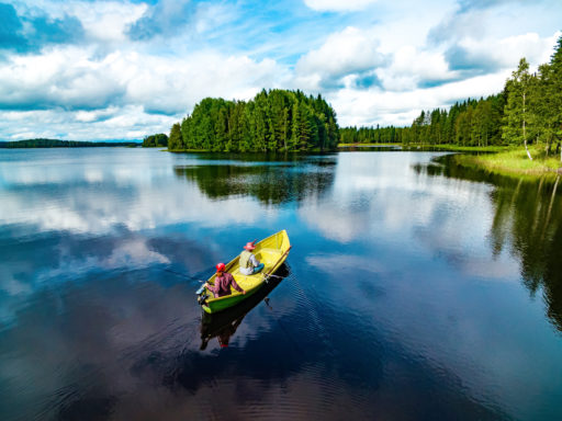 Aerial view of fishing boat with couple in blue summer lake in F